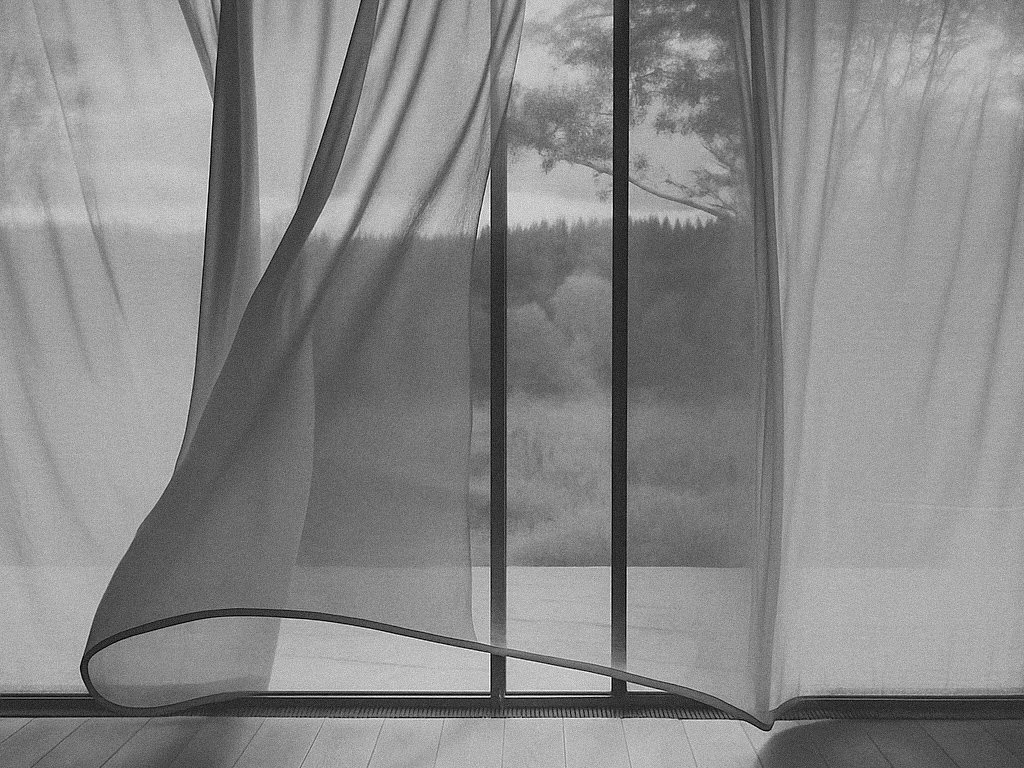 black and white sheer curtain moving gently by the window