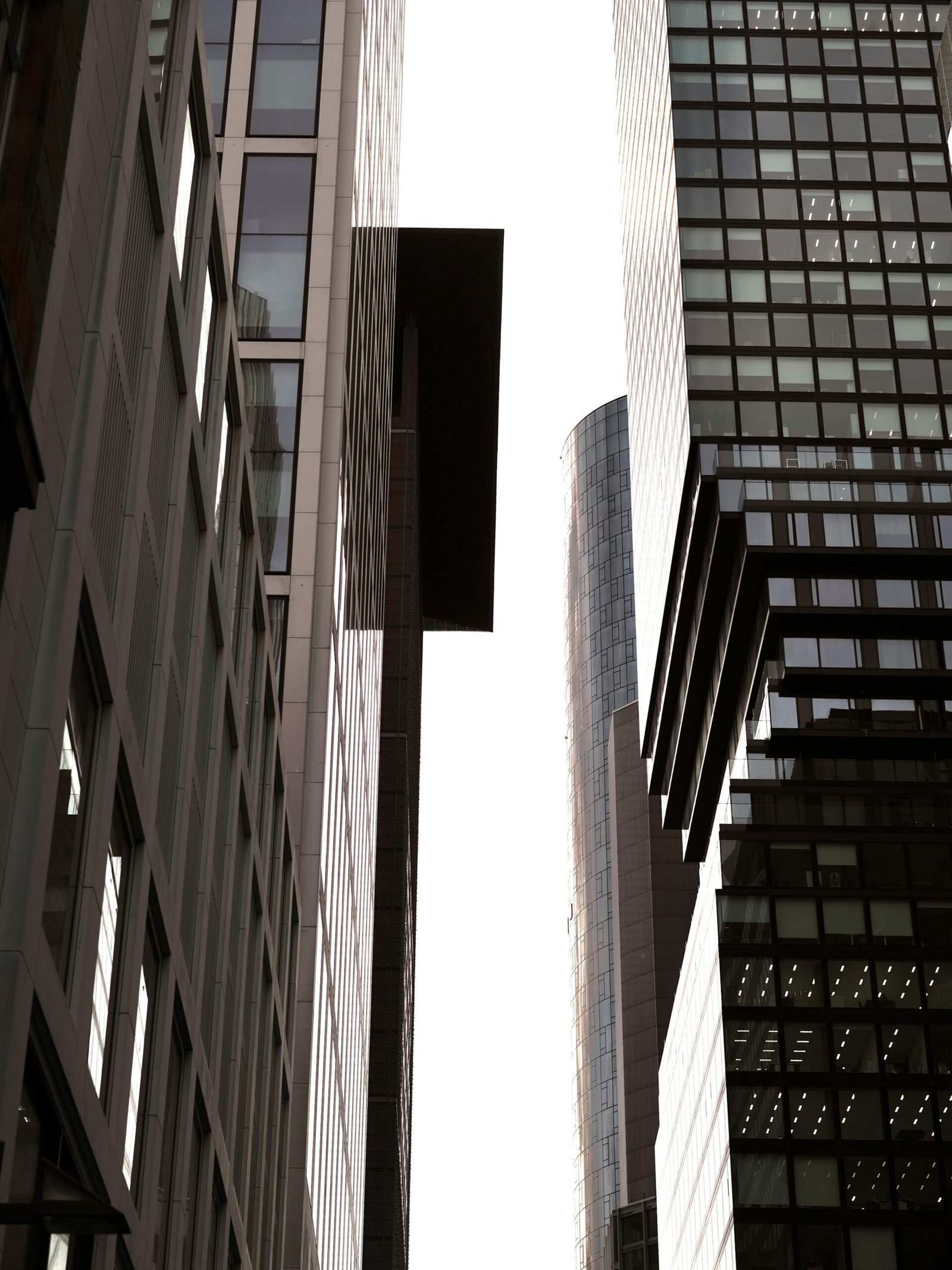 Narrow space between high city buildings where light slips through — contrast of shadow and brightness.